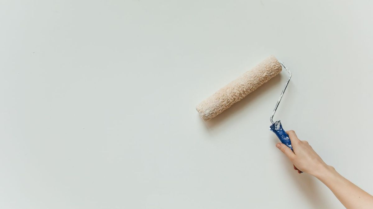 Application d'une peinture de façade au rouleau sur un enduit préparé